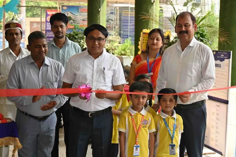 The book fair at Sunbeam School Ballia being opened with a ribbon, staff and junior-school children at the display tables.