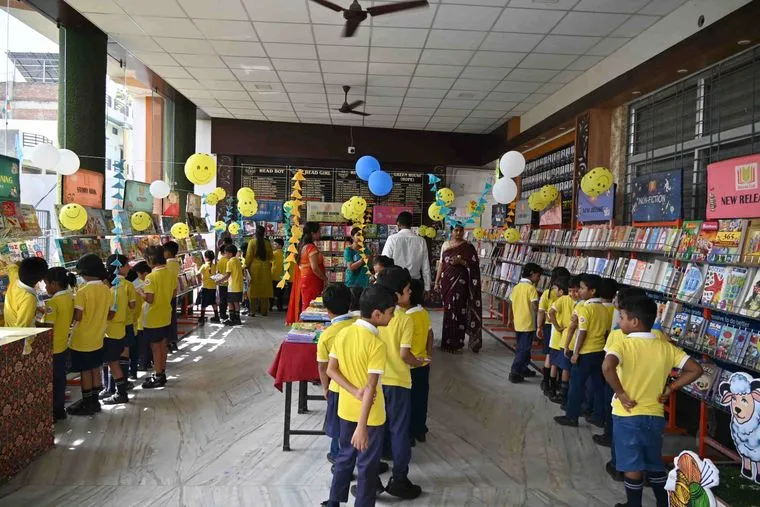 Students of Sunbeam School Ballia filing along book racks lined down both sides of a school corridor during the book fair.