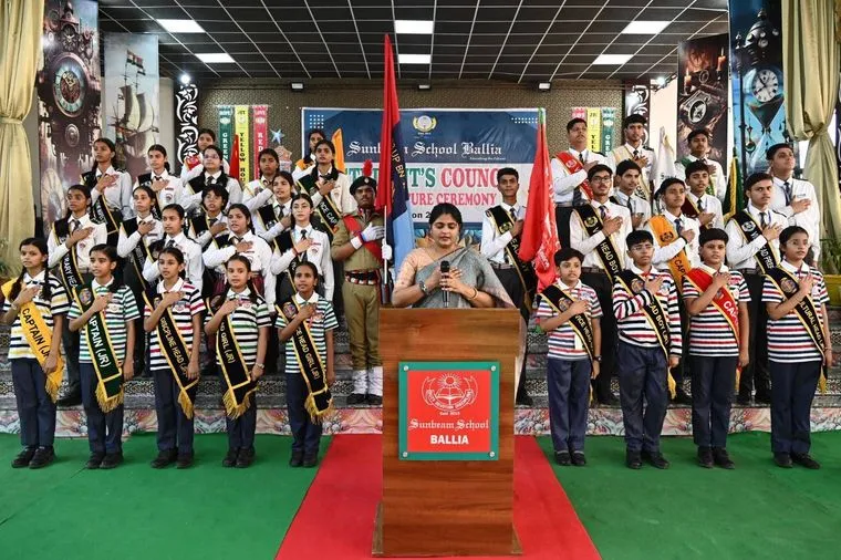 The NCC contingent of Sunbeam School Ballia drawn up in ranks on stage in khaki with red plumes, an officer standing at each end of the line.